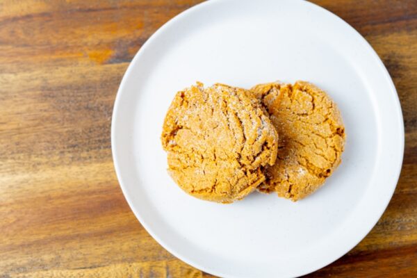 Two ginger molasses cookies on a plate. These cookies are available at Simply Baked Catering in Winchester, Ontario.