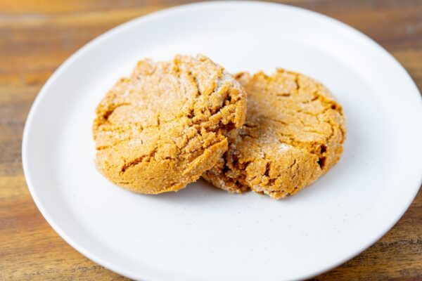 Two ginger molasses cookies on a plate. These cookies are available at Simply Baked Catering in Winchester, Ontario.