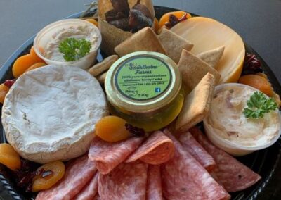 Image of a party platter with pita bread, dip, brie, salami, and dried fruits, and a small jar of local honey from Smirlholm Farms. Catering service by Simply Baked Catering Inc., Winchester, Ontario, Canada.