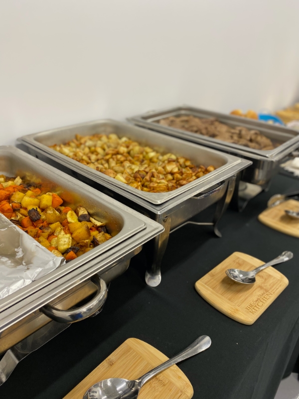 Three chafing dishes on display at an event catered by Simply Baked Catering Inc. Menu included potatoes, sliced roast beef, and roasted root vegetables.