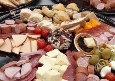 Image of a catered party platter from Simply Baked Catering Inc. of Winchester, Ontario. Includes a cheese ball, a variety of deli meats and sausages, a variety of cheeses, and other finger foods.