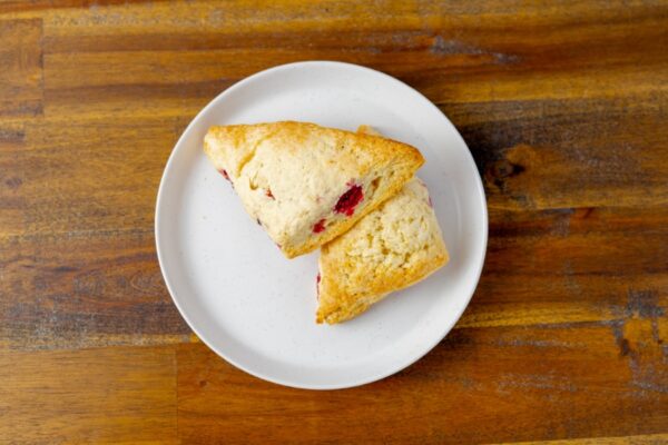 Two raspberry scones on a plate. These delicious scones are available at Simply Baked Catering Inc. in Winchester, Ontario.