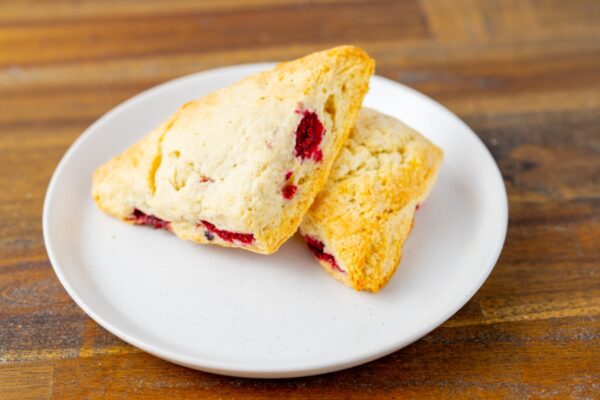 Two raspberry scones on a plate. These delicious scones are available at Simply Baked Catering Inc. in Winchester, Ontario.