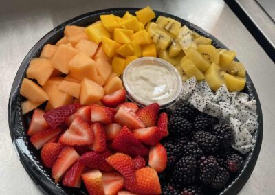 Mixed fruit party platter with fruit dip, strawberries, melon, mango, kiwi, passionfruit, and blackberries. Catering service by Simply Baked Catering Inc., located southwest of Ottawa, Ontario.